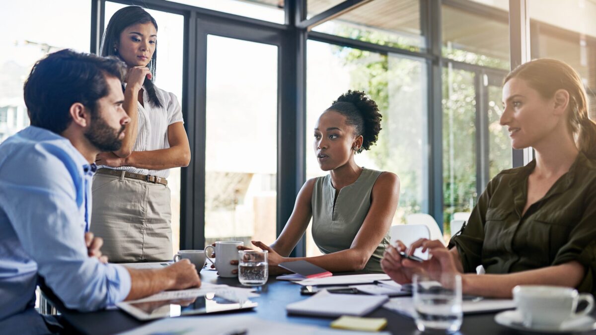 Colleagues in discussion at a bright, modern office.